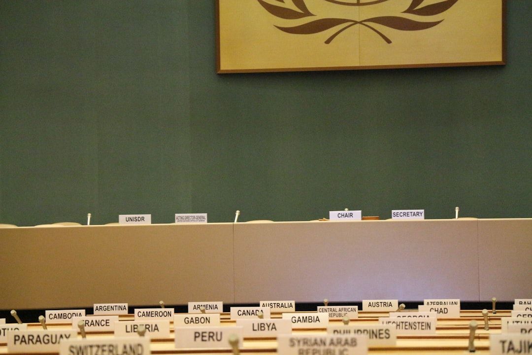 Sala de conferencias con placas de delegaciones y emblema internacional que invita a reflexionar: Descubre dónde trabaja un biomedico y las mejores salidas laborales en 2024