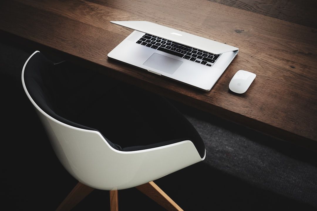 Descubre dónde trabaja un financiero y las mejores oportunidades laborales en el sector financiero en un escritorio de madera con portátil, ratón inalámbrico y silla moderna